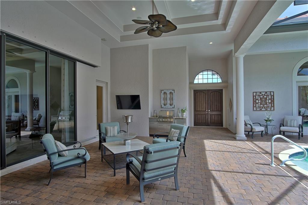 7389 Byrons Way Naples, FL 34113 - Photo 7 of 35 a living room with furniture a rug and a chandelier
