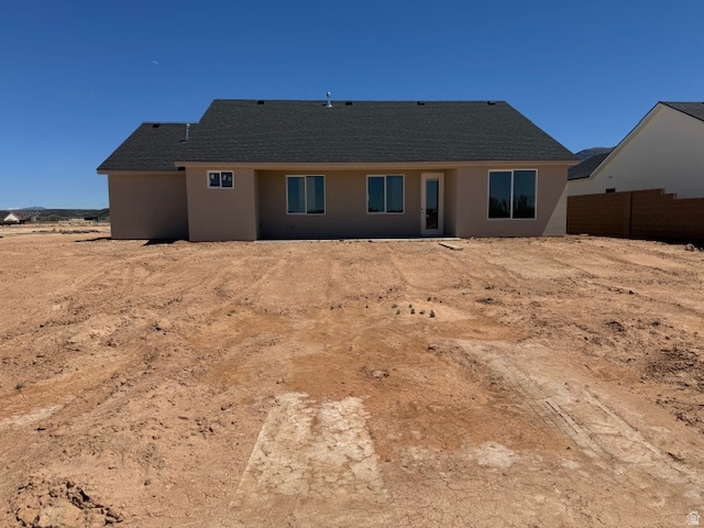5005 North 75 East Enoch, UT 84721 - Photo 21 of 37 Back of property with stucco siding and a shingled roof