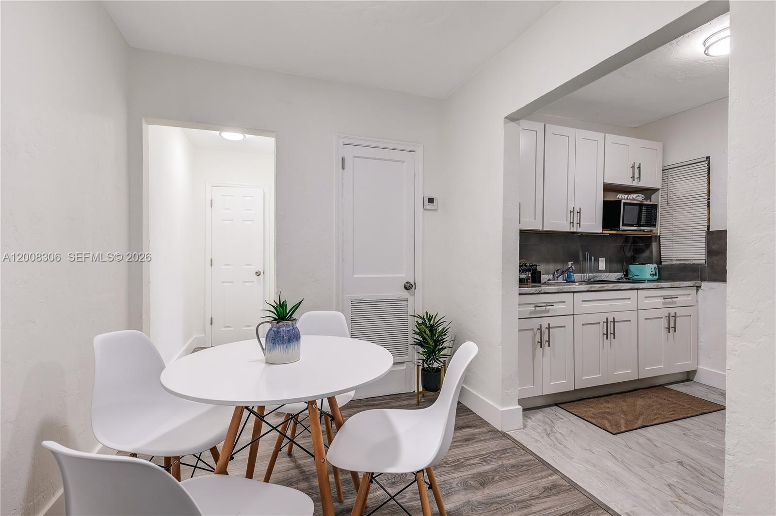 327 Northeast 55th Street, Unit 2 Miami, FL 33137 - Photo 4 of 14 a kitchen with stainless steel appliances a dining table and chairs