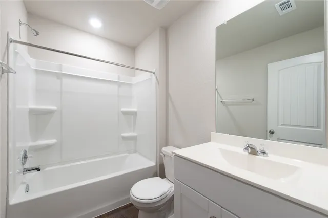 a bathroom with a bathtub shower sink vanity mirror and toilet