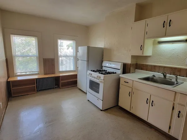 a kitchen with stainless steel appliances a stove a sink and white cabinets