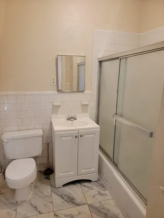 a bathroom with a toilet sink and mirror