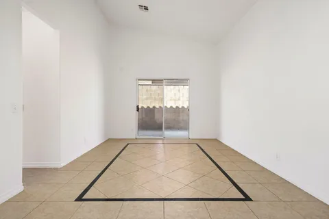 a view of an empty room with closet and a window