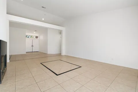 a large kitchen with stainless steel appliances granite countertop a refrigerator a oven and a white cabinets with wooden floor