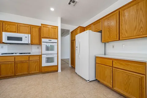 a kitchen with stainless steel appliances granite countertop a sink cabinets and wooden floor