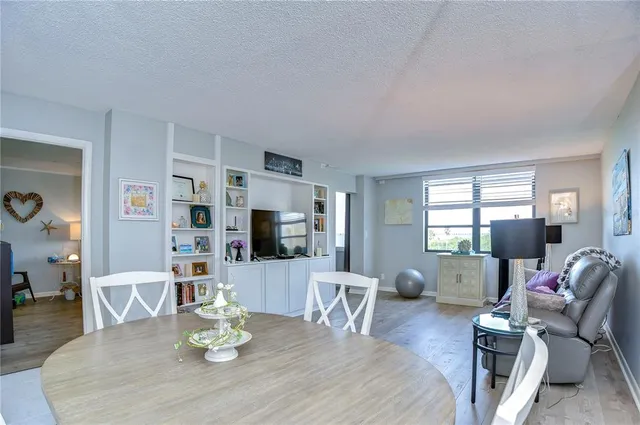a living room with furniture a wooden floor and a potted plant