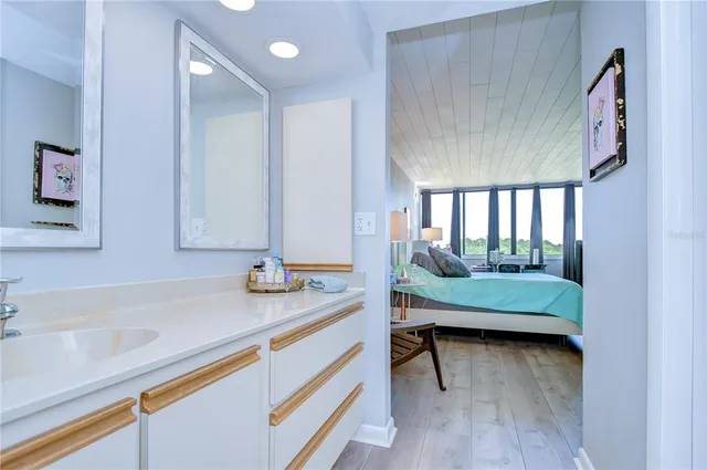 a kitchen with stainless steel appliances a stove top oven a sink a dining table and chairs with wooden floor