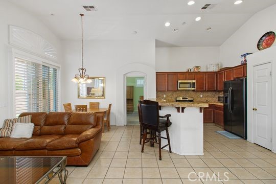 4516 Streamport Drive Riverside, CA 92505 - Photo 11 of 31 a living room with furniture a flat screen tv and kitchen view