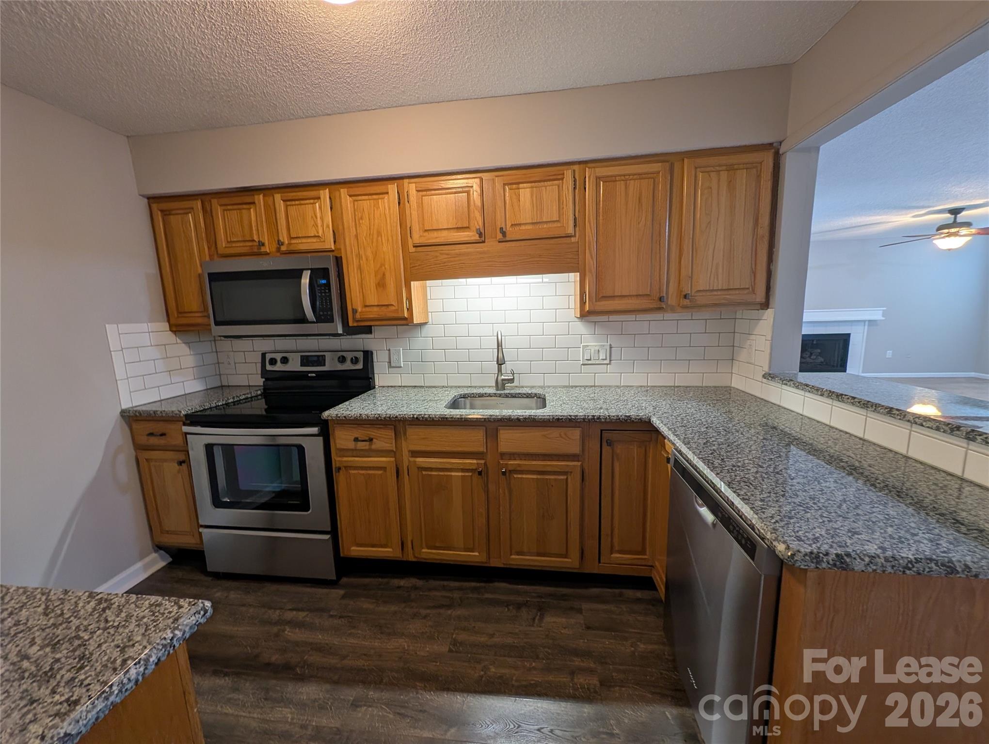 5001 Sharon Road, Unit K Charlotte, NC 28210 - Photo 2 of 24 a kitchen with granite countertop a stove top oven sink and cabinets