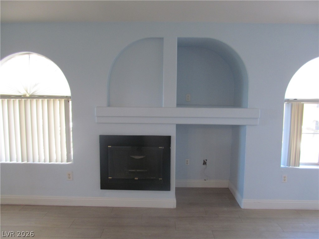 7950 West Flamingo Road, Unit 2048 Las Vegas, NV 89147 - Photo 12 of 24 Arched windows and a built-in entertainment center create a captivating focal point in this inviting space.