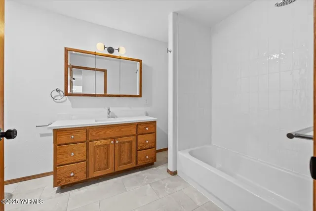 a bathroom with a tub sink and mirror