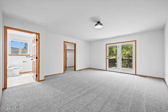 an empty room with windows and bathroom view