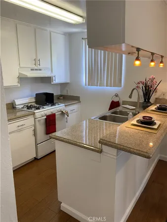 a kitchen with stainless steel appliances granite countertop a sink a stove and a granite counter tops