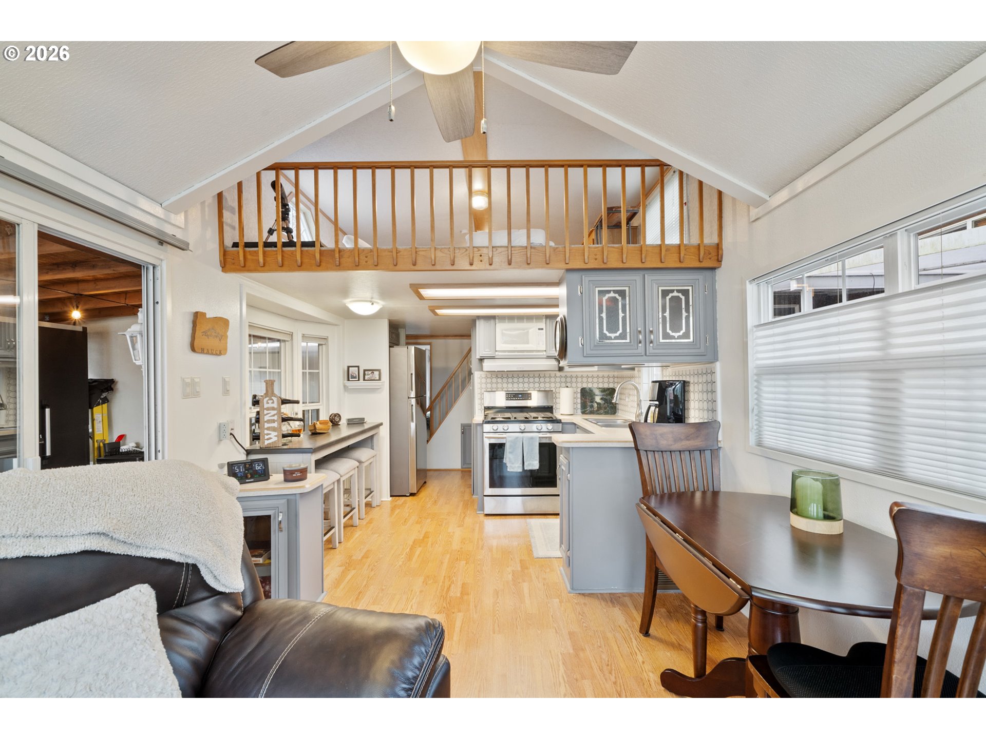 37395 North Fork Road, Unit 13 Nehalem, OR 97131 - Photo 13 of 34 a open kitchen with stainless steel appliances kitchen island granite countertop a stove a refrigerator a sink a dining table and chairs
