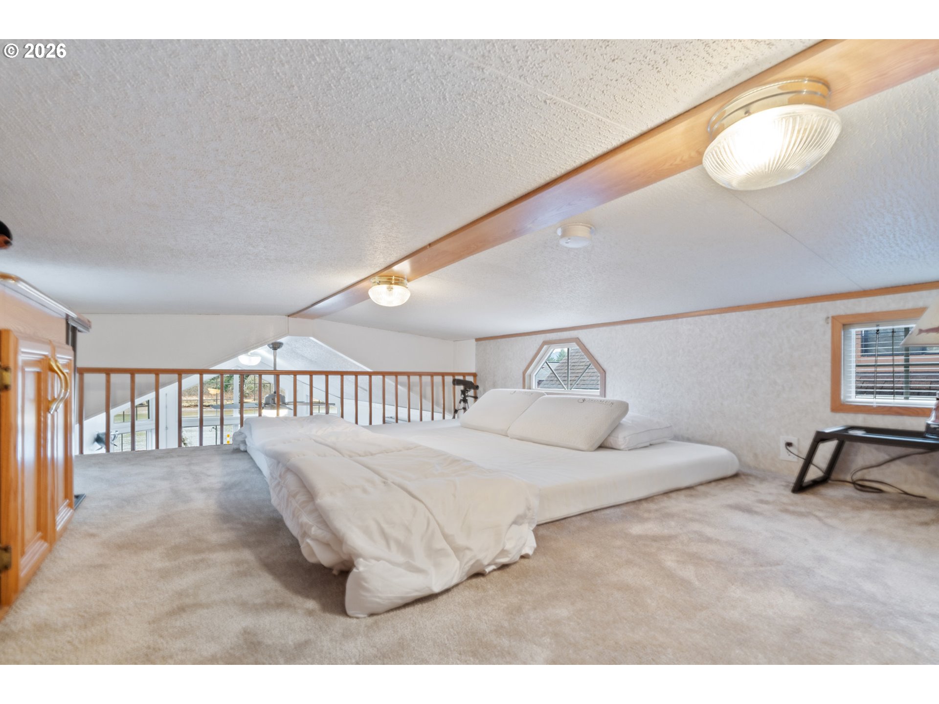 37395 North Fork Road, Unit 13 Nehalem, OR 97131 - Photo 25 of 34 a bedroom with a bed and a chandelier