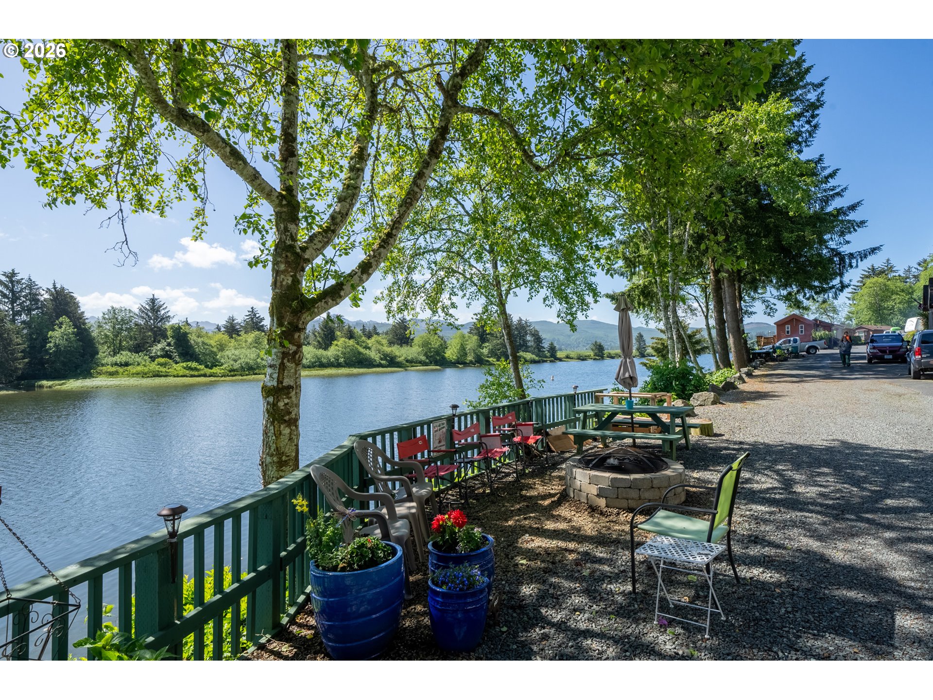 37395 North Fork Road, Unit 13 Nehalem, OR 97131 - Photo 29 of 34 a view of a lake with a bench under an umbrella
