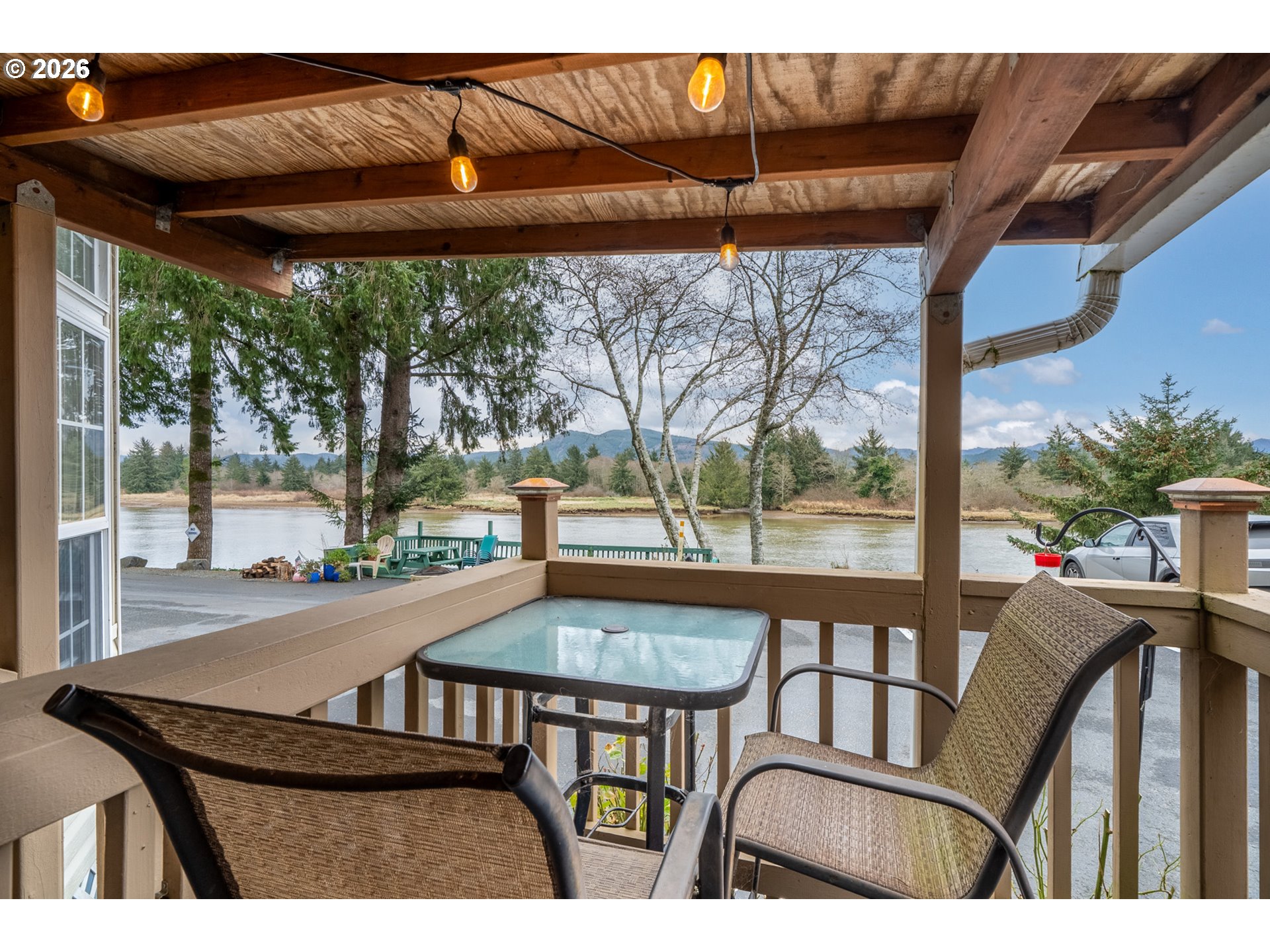 37395 North Fork Road, Unit 13 Nehalem, OR 97131 - Photo 6 of 34 a view of a patio with table and chairs under an umbrella with a small yard