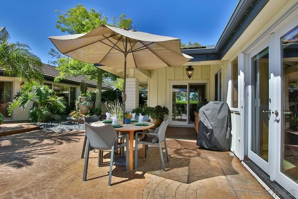 17695 Valle Verde Road Poway, CA 92064 - Photo 22 of 63 a view of a patio with table and chairs under an umbrella