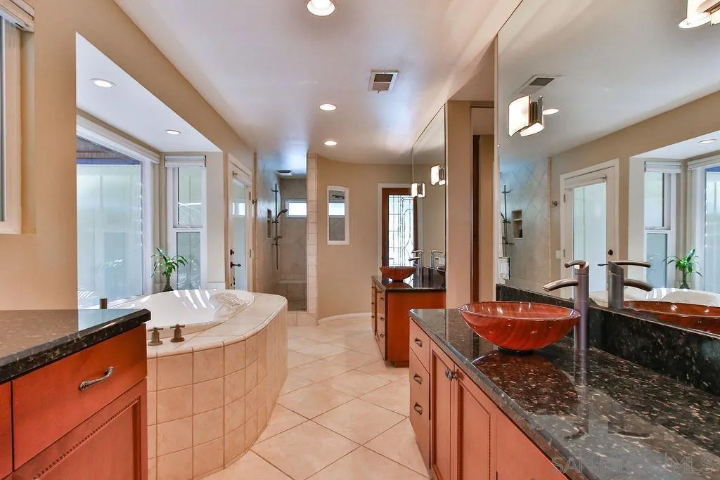17695 Valle Verde Road Poway, CA 92064 - Photo 28 of 63 a large bathroom with double vanity sinks a large mirror and a shower