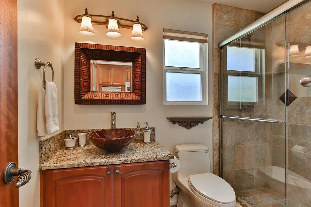 17695 Valle Verde Road Poway, CA 92064 - Photo 50 of 63 a bathroom with a granite countertop sink toilet and shower
