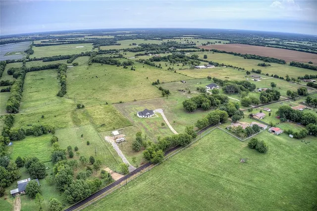 a view of a lush green field with lots of green bushes in it