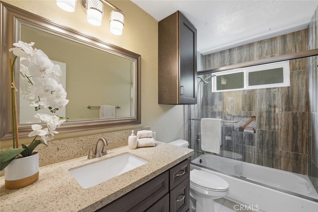 916 Othello Street Arcadia, CA 91006 - Photo 25 of 56 a bathroom with a granite countertop sink a toilet a mirror and shower