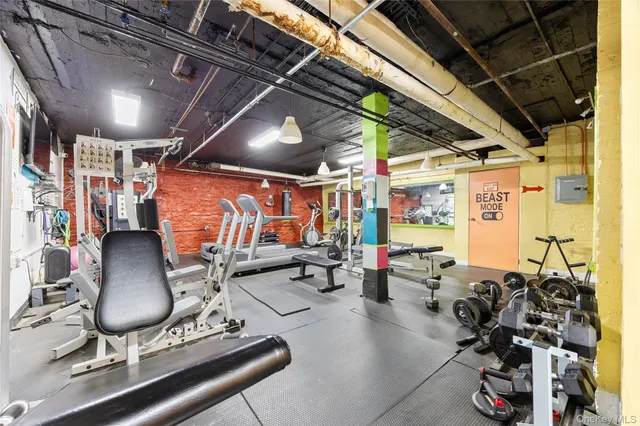 a view of a livingroom with furniture a fireplace a chandelier and windows