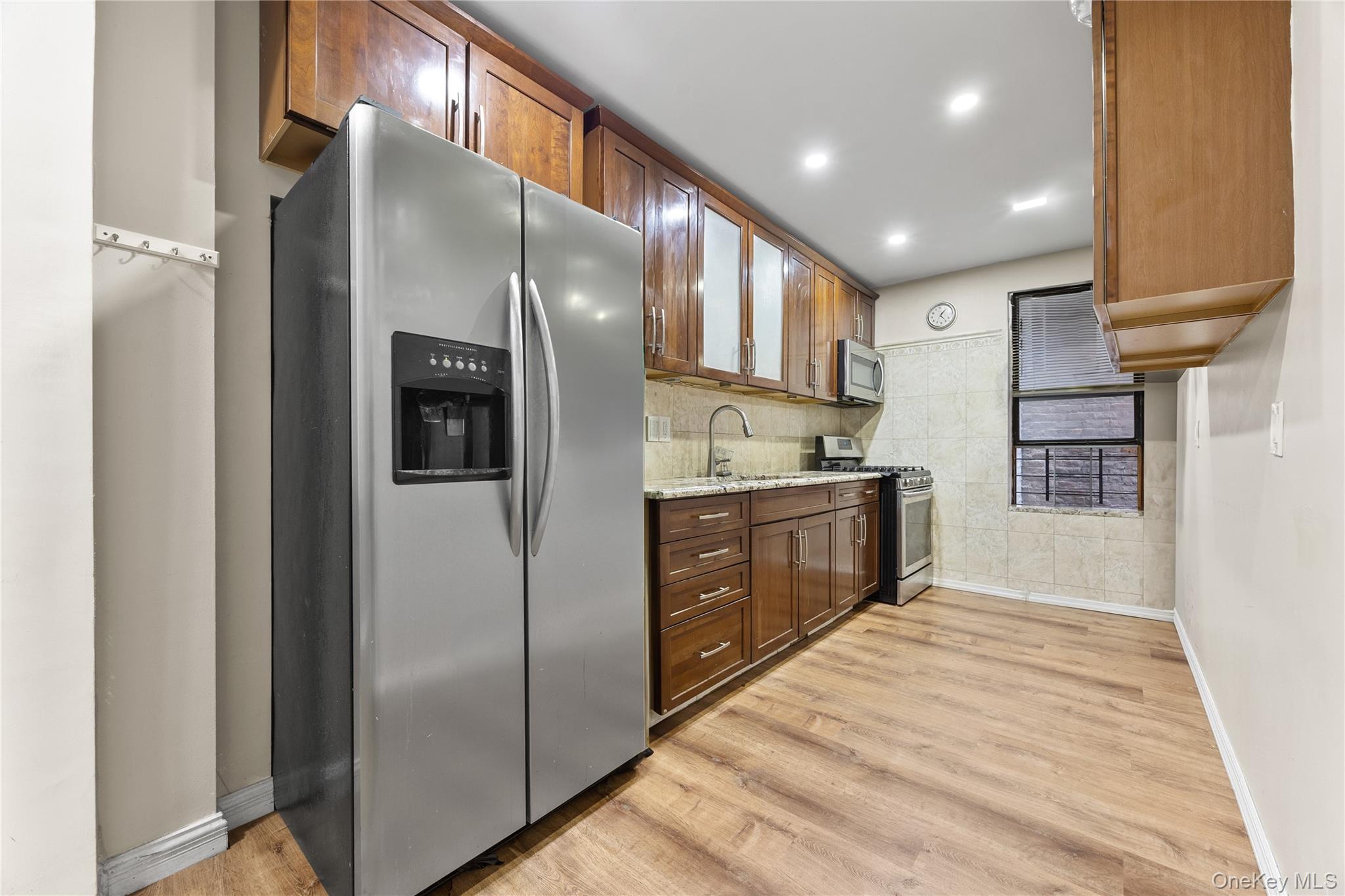 1670 Longfellow Avenue, Unit 3J Bronx, NY 10460 - Photo 5 of 23 a kitchen with stainless steel appliances kitchen island granite countertop a refrigerator and a sink