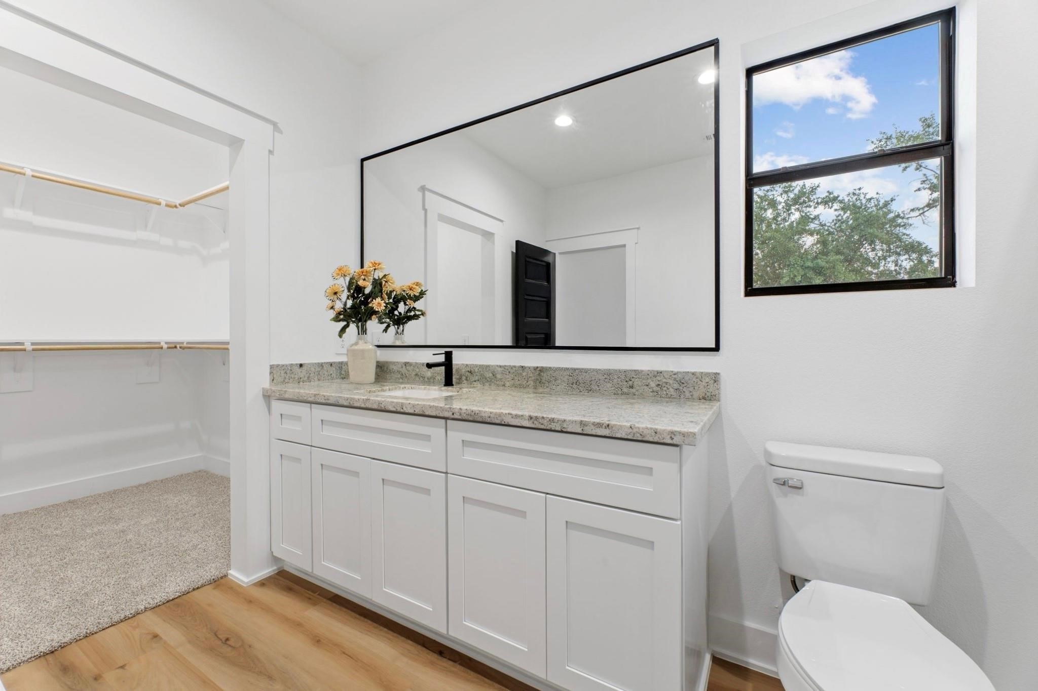 518 Clinton Street, Unit B Conroe, TX 77301 - Photo 35 of 50 a bathroom with a toilet a sink and mirror
