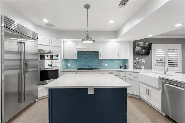 a kitchen with stainless steel appliances kitchen island granite countertop a sink and cabinets
