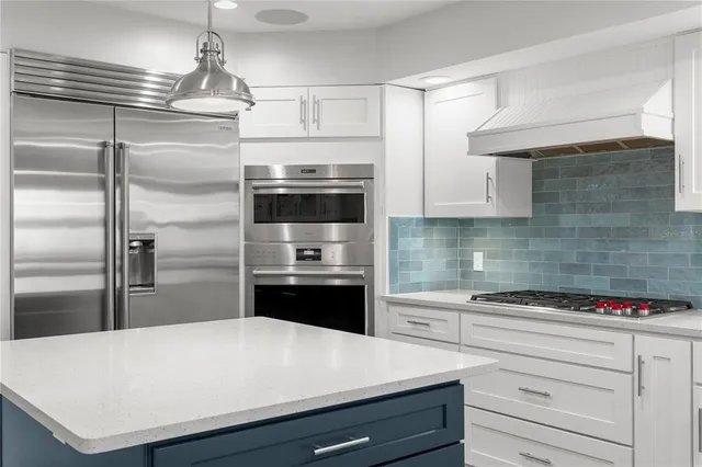 a kitchen with stainless steel appliances kitchen island granite countertop a stove and a sink