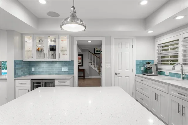 a spacious bedroom with a bed a couch and a chandelier