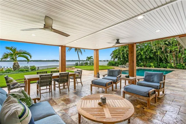 a view of a swimming pool with an outdoor seating and a yard
