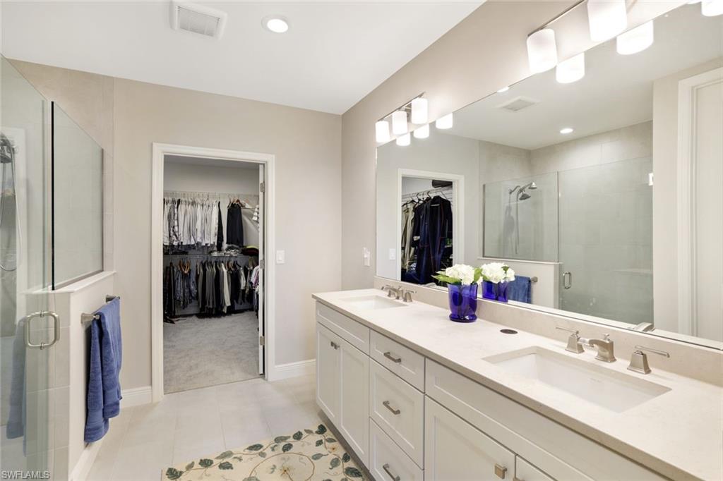 2647 Seychelles Circle, Unit 2204 Naples, FL 34112 - Photo 13 of 29 a en suite bathroom with double vanity and a mirror