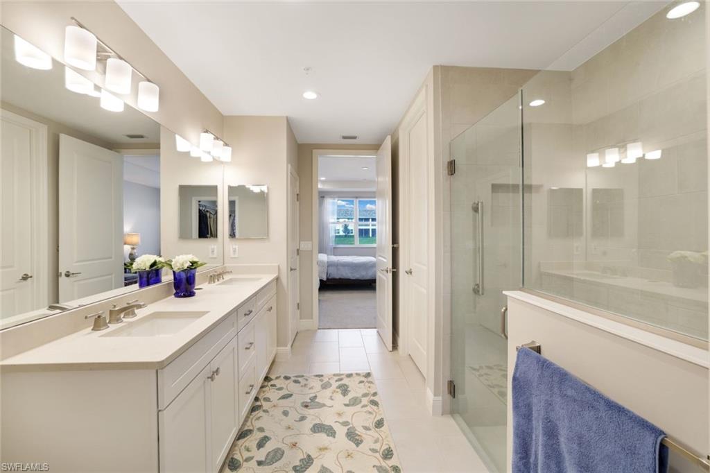 2647 Seychelles Circle, Unit 2204 Naples, FL 34112 - Photo 14 of 29 a bathroom with a sink vanity granite tub and shower