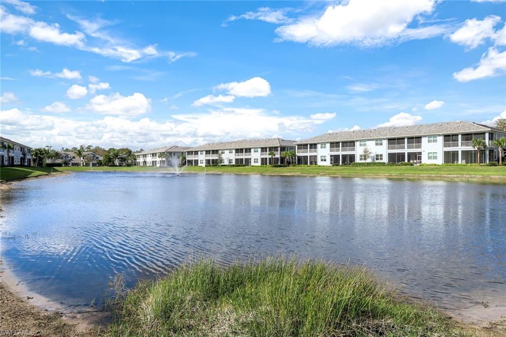2647 Seychelles Circle, Unit 2204 Naples, FL 34112 - Photo 19 of 29 a view of a lake with a big yard and large trees