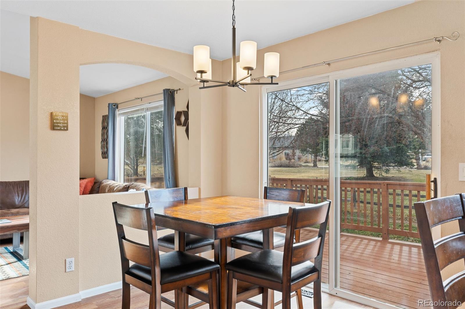 1189 Fall River Circle Longmont, CO 80504 - Photo 11 of 46 a view of a dining room with furniture wooden floor and a chandelier