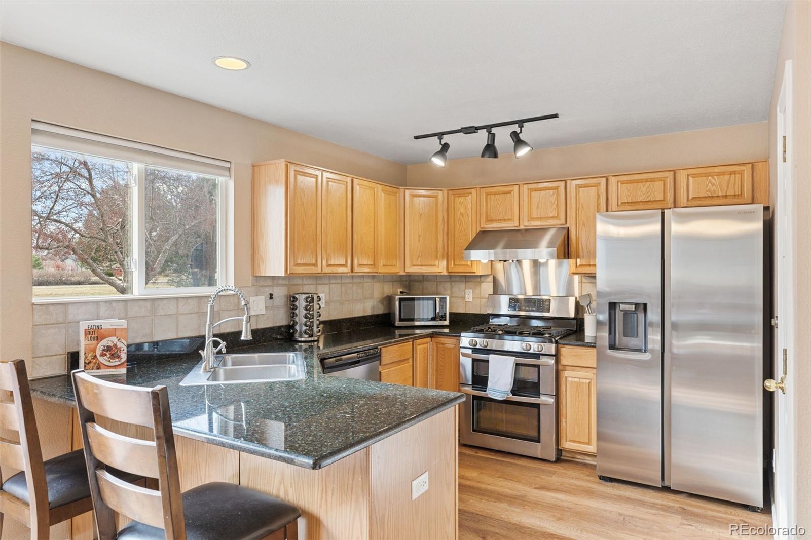 1189 Fall River Circle Longmont, CO 80504 - Photo 13 of 46 a kitchen with stainless steel appliances granite countertop a stove a sink and a refrigerator