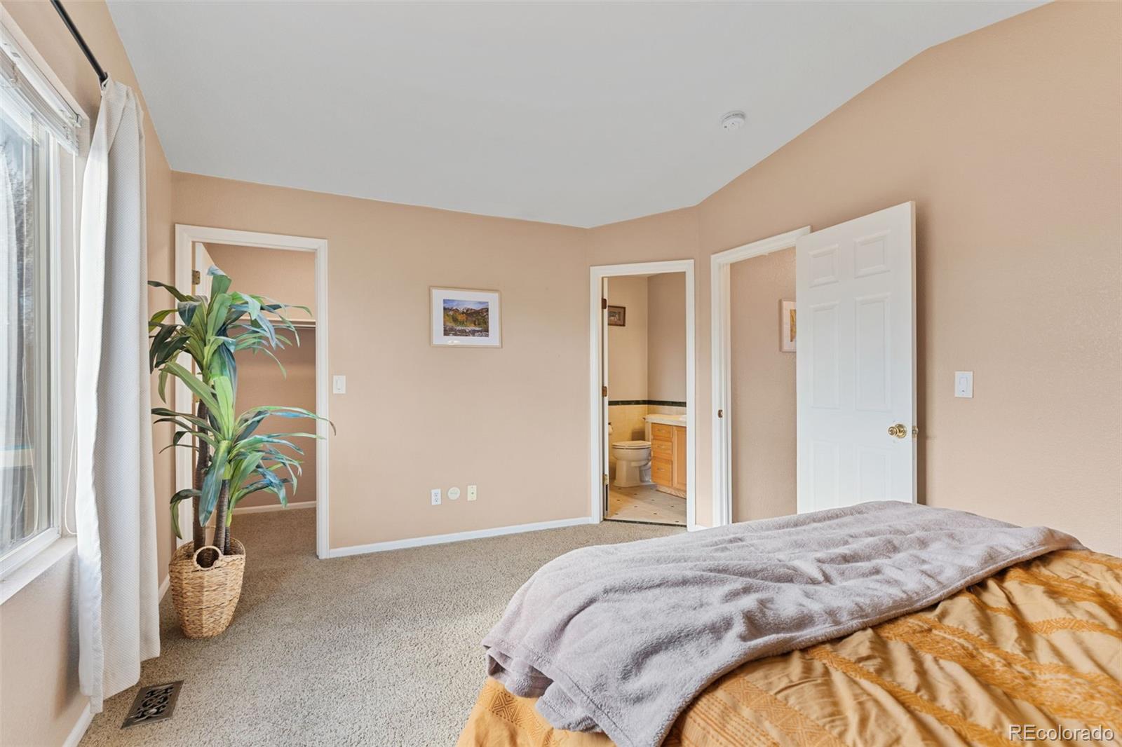1189 Fall River Circle Longmont, CO 80504 - Photo 22 of 46 a bedroom with a bed and potted plant