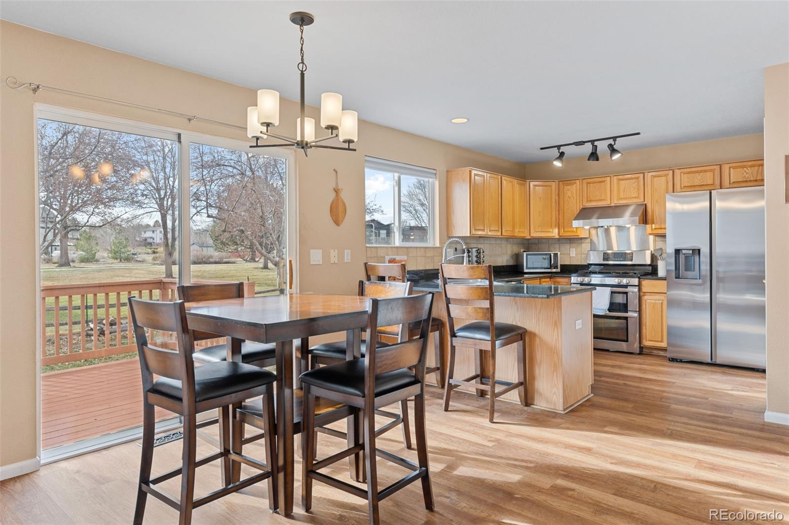 1189 Fall River Circle Longmont, CO 80504 - Photo 10 of 46 a dining room filled chandelier and wooden floor