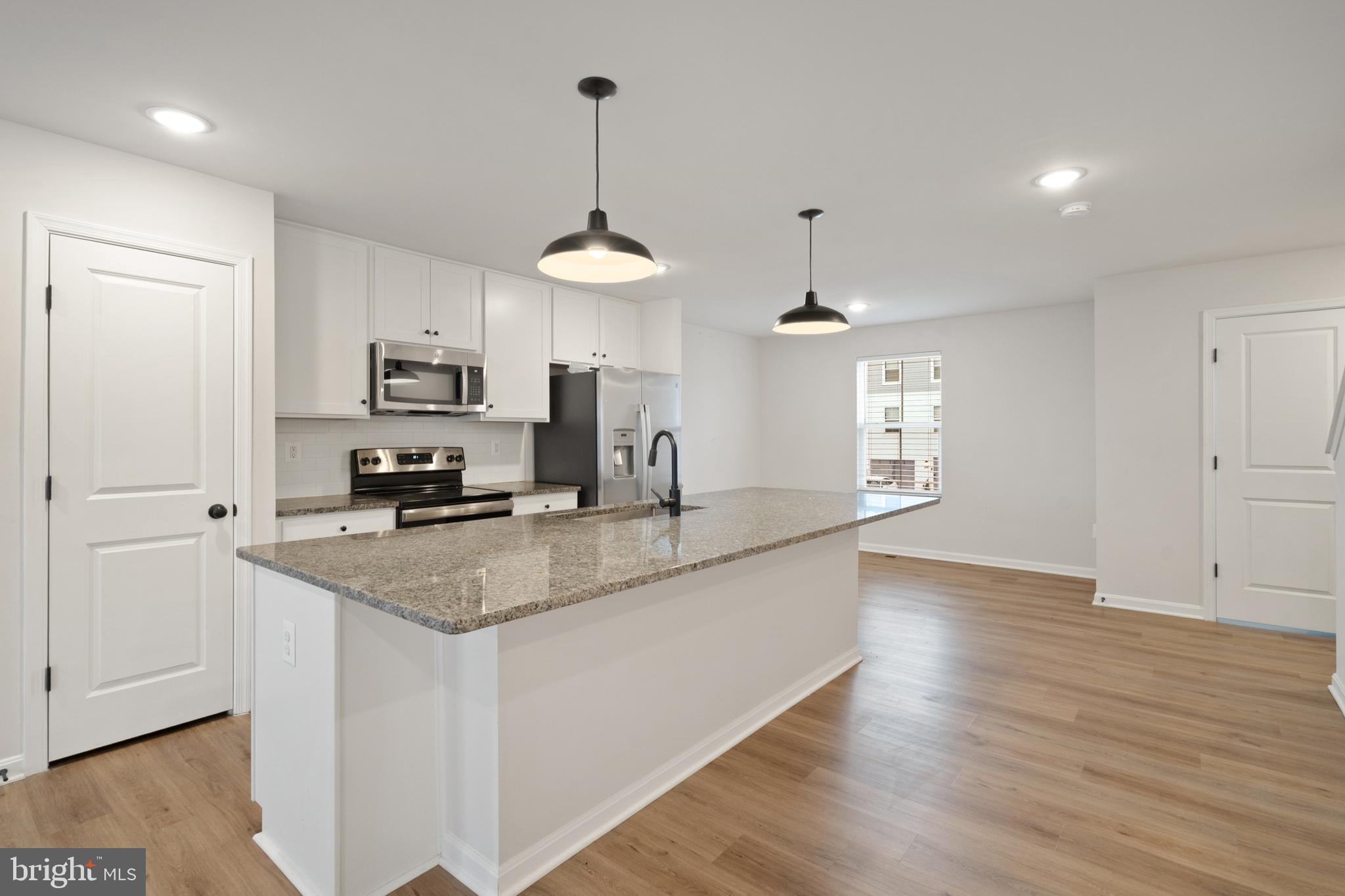 51 Thrower Road Hedgesville, WV 25427 - Photo 13 of 38 a kitchen with kitchen island granite countertop a sink a counter space appliances and cabinets
