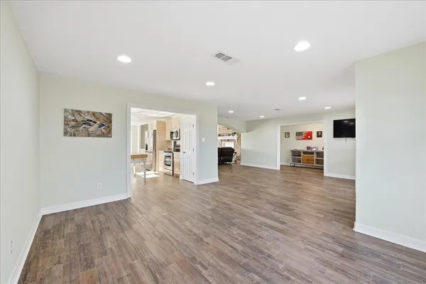 a view of a kitchen with a sink a refrigerator and wooden floor