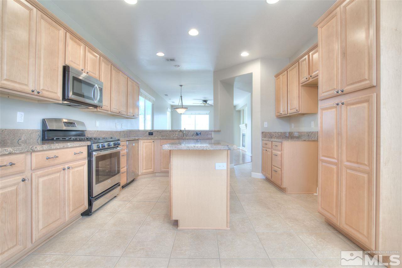 10490 Chadwell Drive Reno, NV 89521 - Photo 11 of 36 a large kitchen with stainless steel appliances granite countertop a stove a sink and a refrigerator