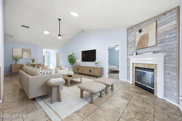 a living room with furniture a fireplace and a flat screen tv