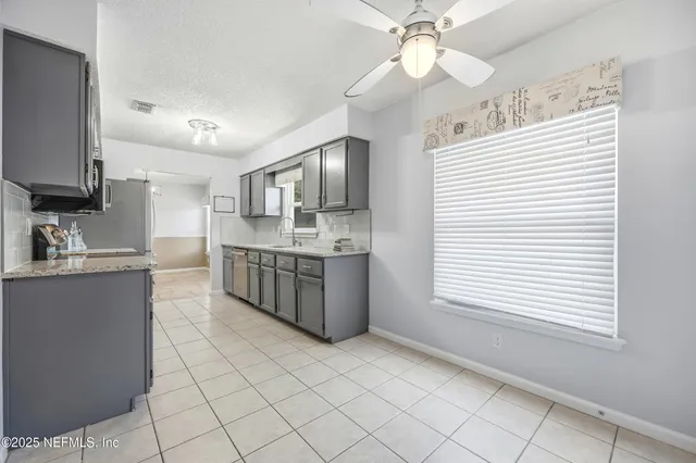 a large kitchen with kitchen island granite countertop a sink cabinets and window