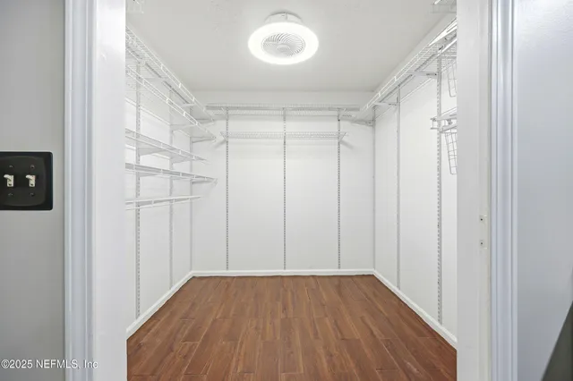 a view of a room with wooden floor and a window