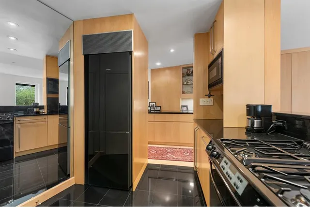 a kitchen with stainless steel appliances granite countertop a stove a sink and a refrigerator