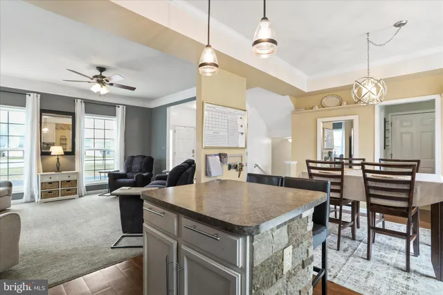 a kitchen with a stove a counter space dining table and chairs