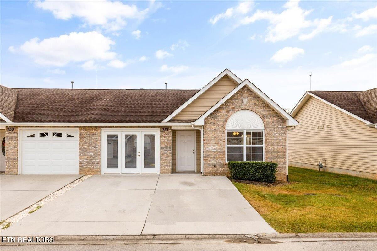 a view of a white house next to a yard with potted plants