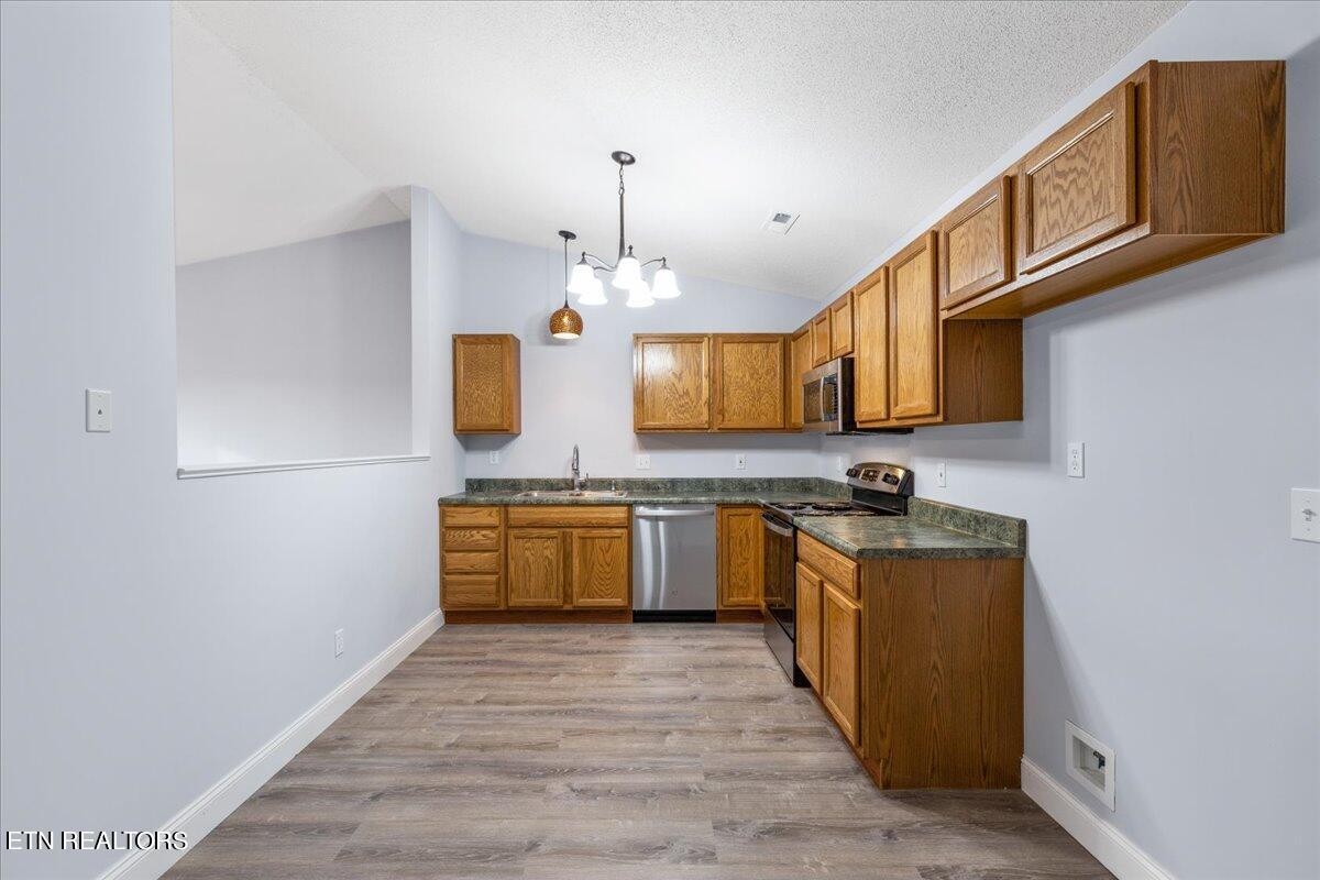 731 High Point Way, Knoxville, TN 37912 - Photo 11 of 25 a kitchen with stainless steel appliances granite countertop a sink a stove top oven a chimney wooden cabinets and entryway